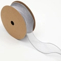 Macro detail of gray chiffon ribbon with ruffled edges on a brown cardboard spool - Gray
