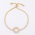 Dettaglio del bracciale dorato con zirconi incastonati nel cerchio e catena a scatola - Anello