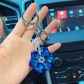 Gros plan du porte-clés flocon de neige en cristal bleu tenu dans une voiture - Bleu