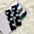 Detail of black tabi split-toe socks with grey geometric jacquard on soft plush rug - 35-41 / Black White Blocks