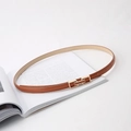 Gros plan d'une fine ceinture en cuir marron avec boucle géométrique dorée élégante - Kaki
