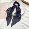 Détail d'un chouchou en mousseline bleu marine avec rubans et étoiles dorées - Bleu Marine Avec Étoiles Dorées