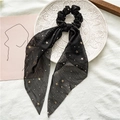 Détail d'un chouchou en mousseline noire avec étoiles dorées et long ruban élégant - Noir Avec Étoiles Dorées
