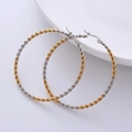 Close-up of 50mm twisted two-tone gold and silver hoop earrings in chunky rope style - Two-tone (Gold+Silver)