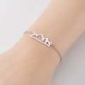 Pulsera minimalista de acero inoxidable con colgante de montaña en la muñeca de mujer - Color Acero