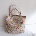 Détail d'un sac cabas en toile à fleurs avec motifs roses et jaunes sur tissu durable - Beige Floral