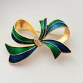 Détail d'une broche nœud dorée avec émail bleu et vert et accents en cristal - Style Nœud Bleu Vert (D)