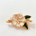 Detail van de bloemspeld met wit geëmailleerde bloembladen, groene bladeren en parels - Pioenroos Broche
