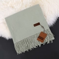 Soft pale green cashmere scarf with tassel fringe details on a plush white rug - Mint Green
