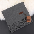 Morandi grey cashmere scarf with twisted tassels folded on white fur and grey surface - Heather Grey
