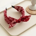 Detail of red paisley knot headband with bow on a tray with decorative props - Rabbit Ear Paisley / Burgundy