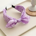 Detail of purple paisley knotted headband with intricate white floral textile patterns - Purple