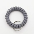 Detail of dark gray matte spiral wrist keychain with flexible elastic texture and metal ring - Light Gray