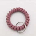 Detail of dusty pink matte spiral wrist keychain with durable metal ring and flexible cord - Dusty Pink