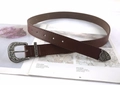 Dettaglio della fibbia in argento intagliato vintage su cintura in pelle marrone stile western - caffè
