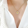 Collana a perle dorate con ciondolo in conchiglia bianca e piccolo cuore al collo - Cuore d'oro