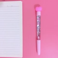 Pink cartoon gel pen with glitter liquid and pink heart topper on a notebook - Love Heart