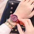 Close-up of a minimalist pink quartz watch with matte strap and daisy charm bracelet - Purple