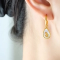 Elegante gouden titanium avocado oorbellen met witte schelp inleg voor dames - Goud