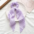 Elegant purple knotted scrunchie with long ribbons and textured fabric on a white plate - Style with Streamer / Purple