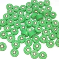 Detailed macro view of green kiwi-shaped polymer clay beads for DIY jewelry making - Kiwi