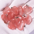 Pink heart-shaped natural agate pendants held in hand with secure metal clasps - Watermelon red