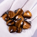 Tiger eye heart pendant necklaces held in hand showing golden brown chatoyancy - Tiger Eye