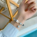 Primer plano de pulsera de cuentas azul océano con dije de flor blanca y cristal azul - Flor