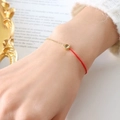 Elegante bracciale con cordino rosso e catena dorata con gemma verde da donna - Marzo Giallo Oliva
