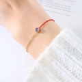 Bracciale minimalista in corda rossa con catena dorata e dettaglio gemma viola tonda - Febbraio Viola