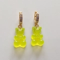 Close-up of candy-style neon green gummy bear earrings with rhinestone gold hoops - Transparent Yellow