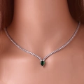 Close-up of a silver tennis necklace featuring a teardrop-shaped green gemstone pendant - Silver Green Emerald Necklace