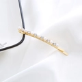 Detailed shot of golden hair clip inlaid with white pearls and sparkling rhinestones - Arched Pearl Rhinestone Bobby Pin