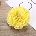 Detailed top view of a realistic yellow fabric peony flower on a wooden background - Bright yellow