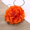 Macro close-up showing the layered fabric petals and orange stamens of the peony hair clip - Orange