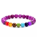 Detailed macro of a purple beaded chakra bracelet with seven colored natural stones - Purple Red Agate 7 Chakra