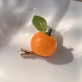 Gros plan sur la barrette orange réaliste avec texture de peau et détail de feuille - A Mandarine / Orange