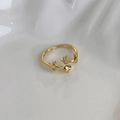 Macro shot of gold tulip ring with micro-pave white zircons on white ceramic base - Gold