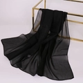 Detail showing sheer black chiffon scarf draped on a gold display stand with elegant texture - Solid Color / Charcoal Black