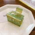 Detail showing square hollow hair claw clip with colorful marble pattern on a tray - Small / Green