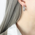 Silver woven C-shaped hoop earrings in titanium steel shown on model - Steel