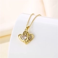 Detalle de un colgante de corazón de oro 18k con un circón grande y piedras decorativas - Dorado