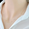 Collar minimalista de cadena bicolor oro y plata en el cuello de una modelo con camisa - Dorado