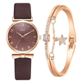Détail d'une montre femme en or rose avec cadran brun et coffret bracelet à breloque étoile - Montre + Bracelet / Café