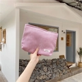 Detailed close-up of pink corduroy texture on a cosmetic bag with a small white label - Lotus Pink