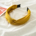 Detalle de diadema de tela amarilla anudada con puntas negras sobre fondo blanco - Amarillo