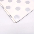Makroaufnahme von weißem Geschenkpapier mit glänzenden silbernen Metalleffekt-Punkten - Silberne Punkte