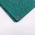 Detailansicht von grünem Geschenkpapier mit botanischem Blatt- und Beerenmuster - Grünes Blatt