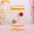 Detail showing soccer and basketball beads floating in yellow liquid hourglass motion toy - Orange Soccer Ball