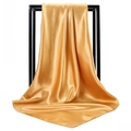 Elegant gold satin square scarf for women with glossy silk texture on a black stand - Turmeric